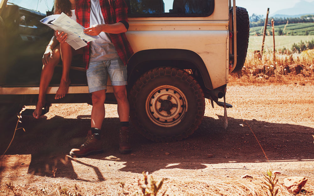 Two people in a jeep looking at a roadmap